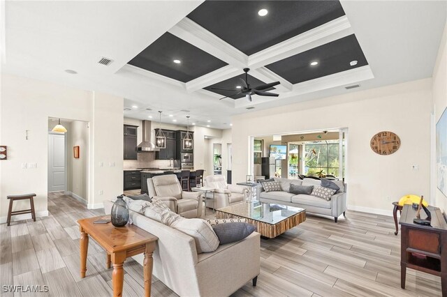 living room featuring ceiling fan, ornamental molding, beamed ceiling, and coffered ceiling