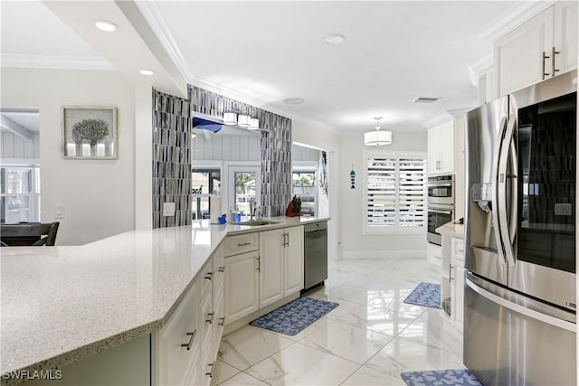 kitchen featuring decorative light fixtures, crown molding, white cabinetry, light stone countertops, and stainless steel appliances