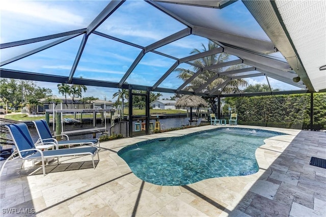 view of swimming pool featuring a water view, a patio, and a lanai