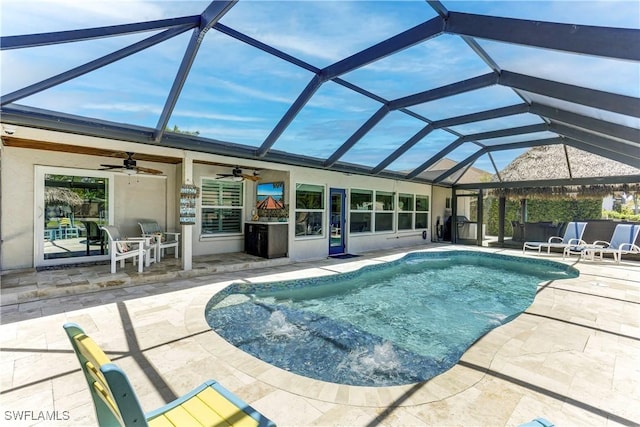 view of pool with ceiling fan, a patio area, and glass enclosure