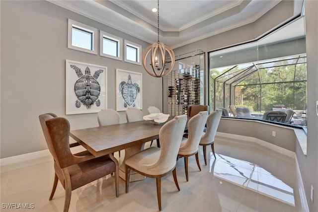 dining room featuring ornamental molding, a raised ceiling, and a chandelier