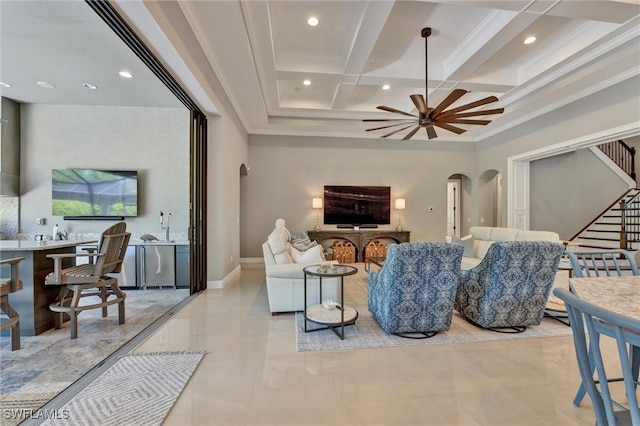 living room with ceiling fan, ornamental molding, beam ceiling, and coffered ceiling