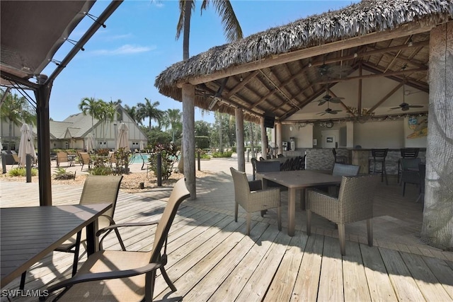 deck with ceiling fan, a gazebo, and a bar