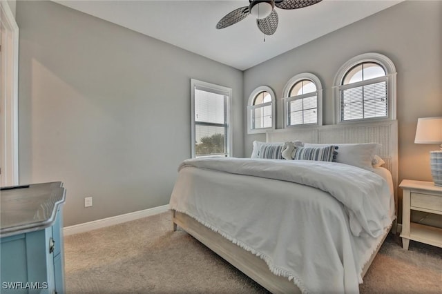 carpeted bedroom with ceiling fan and multiple windows