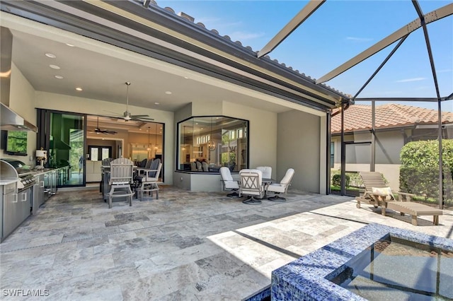 view of patio featuring glass enclosure, ceiling fan, and area for grilling