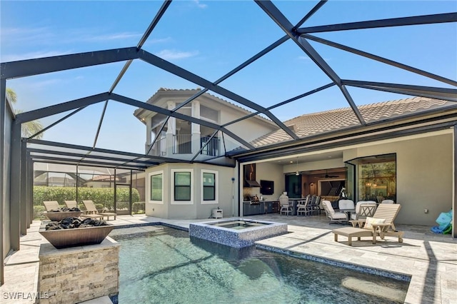 view of pool featuring glass enclosure, a patio area, an in ground hot tub, and ceiling fan