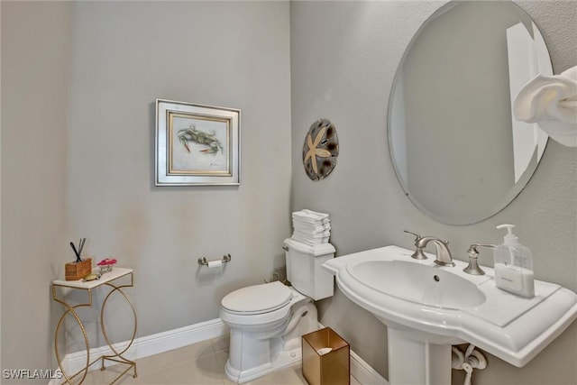 bathroom with toilet, tile patterned floors, and sink