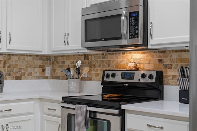 kitchen with backsplash, white cabinetry, and appliances with stainless steel finishes