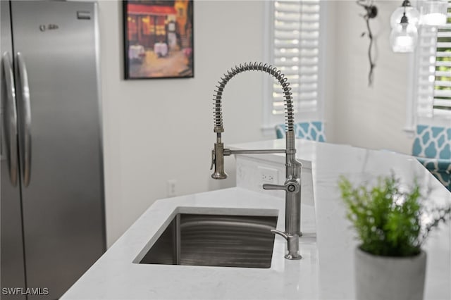 room details featuring sink and stainless steel refrigerator