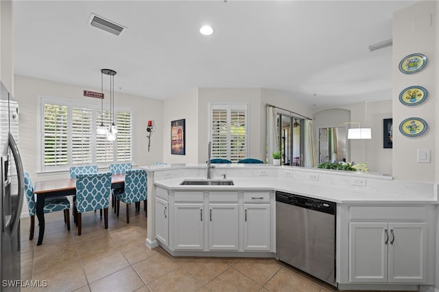 kitchen with decorative light fixtures, sink, light tile patterned flooring, appliances with stainless steel finishes, and white cabinets