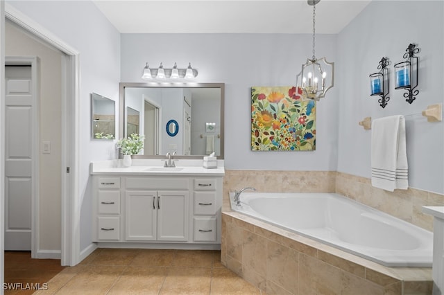 bathroom with tile patterned floors, a relaxing tiled tub, vanity, and a chandelier