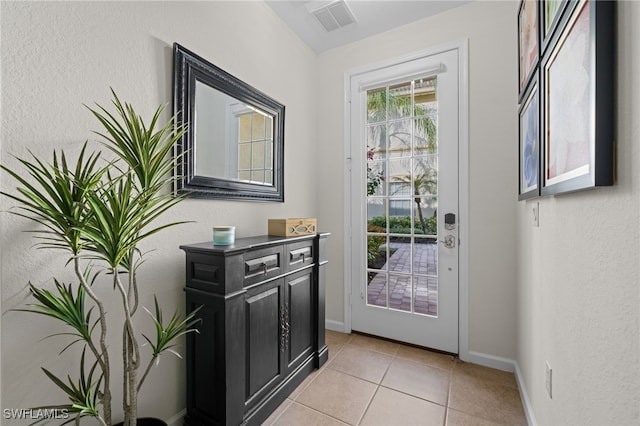 doorway to outside with light tile patterned floors