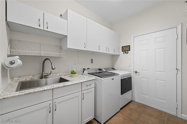 laundry room featuring cabinets, light tile patterned flooring, washing machine and clothes dryer, and sink