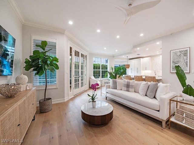 living room with ceiling fan, ornamental molding, and light hardwood / wood-style floors