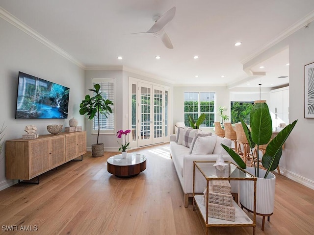 living room featuring light wood-type flooring, french doors, crown molding, and ceiling fan