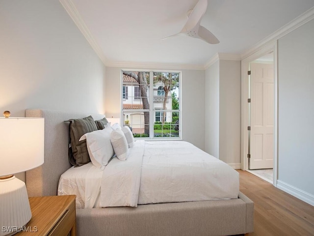 bedroom featuring ceiling fan, crown molding, and light hardwood / wood-style flooring