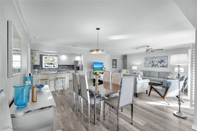 dining area with crown molding, ceiling fan, and light hardwood / wood-style floors