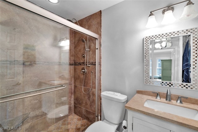 bathroom featuring vanity, toilet, and an enclosed shower