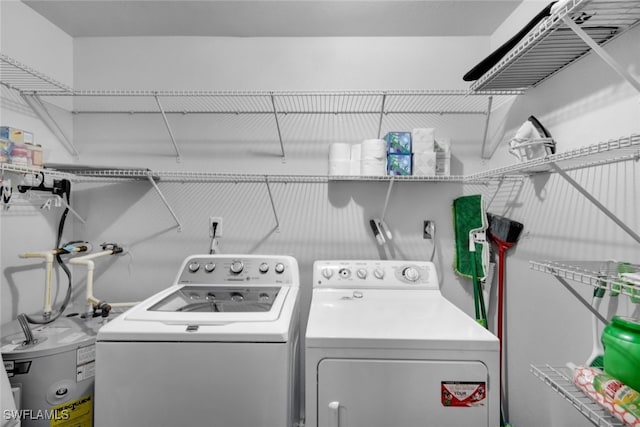 laundry room with water heater and washing machine and dryer