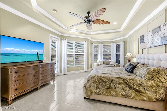 tiled bedroom featuring ceiling fan, a tray ceiling, and ornamental molding