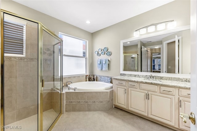 bathroom with tile patterned flooring, vanity, and plus walk in shower