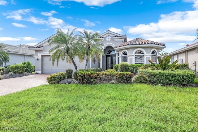 mediterranean / spanish home with a front lawn and a garage