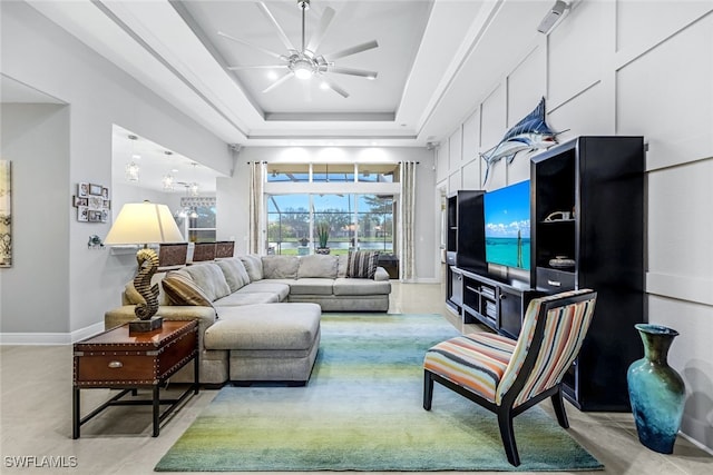 living room featuring ceiling fan and a tray ceiling