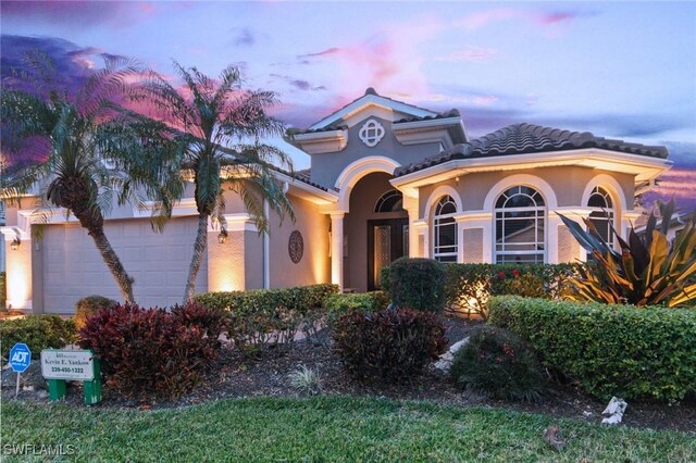 mediterranean / spanish home featuring a garage