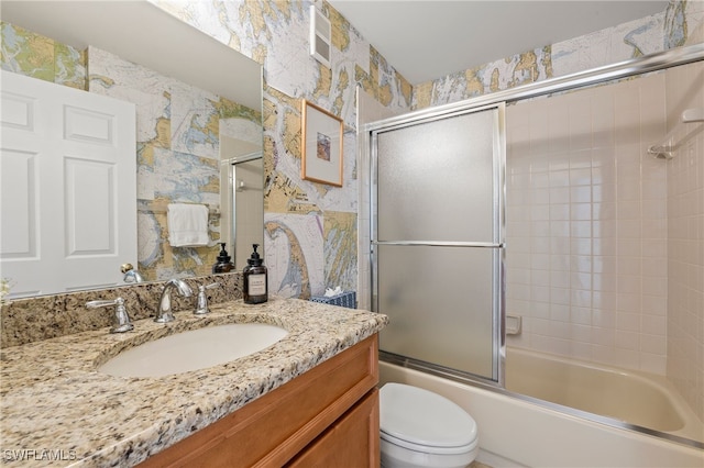 full bathroom featuring bath / shower combo with glass door, vanity, and toilet