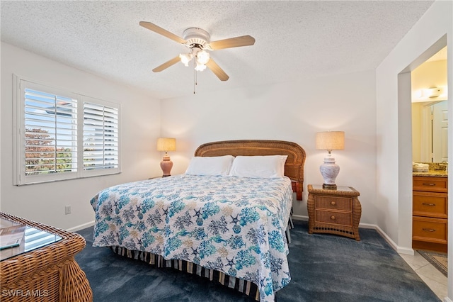 bedroom with ceiling fan, light colored carpet, a textured ceiling, and ensuite bath