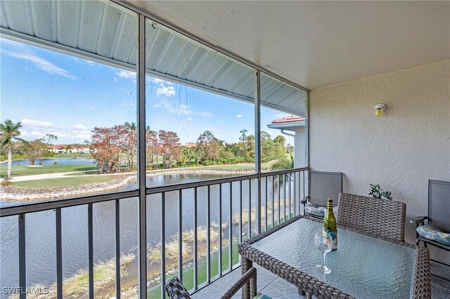 sunroom featuring a water view