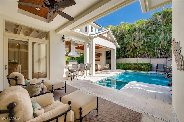 view of pool with ceiling fan, an outdoor bar, and a patio