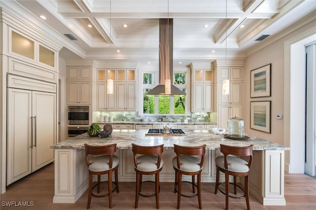 kitchen with cream cabinetry, stainless steel appliances, and a large island