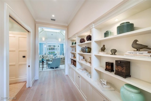 hall featuring crown molding and light hardwood / wood-style floors