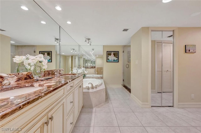 bathroom with tile patterned flooring, shower with separate bathtub, and vanity