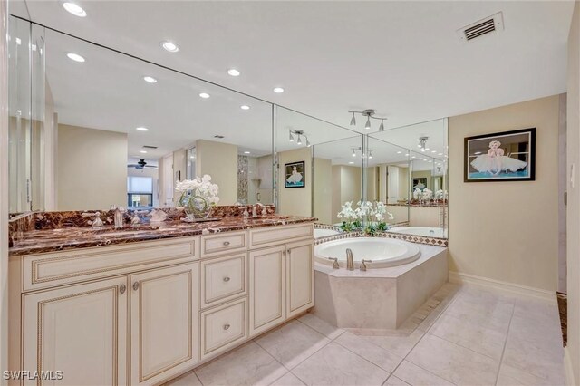 bathroom featuring independent shower and bath, vanity, and tile patterned floors