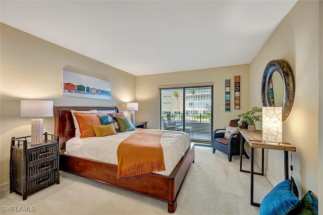 bedroom featuring access to exterior and light carpet