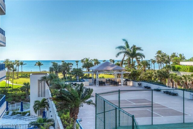 view of tennis court featuring a water view and a gazebo