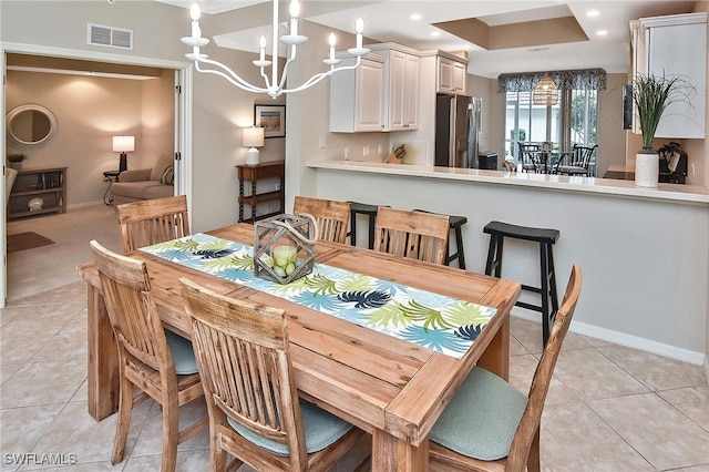 tiled dining area featuring an inviting chandelier