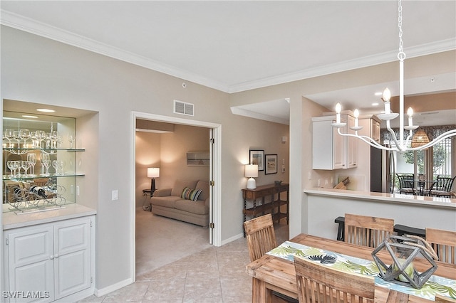 tiled dining room with a chandelier and ornamental molding