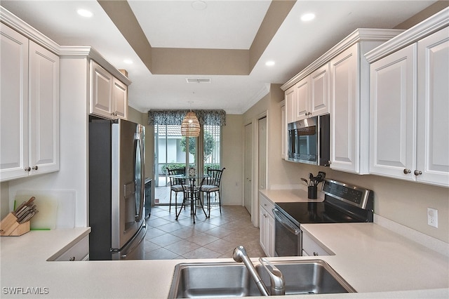 kitchen featuring appliances with stainless steel finishes, sink, white cabinetry, and pendant lighting