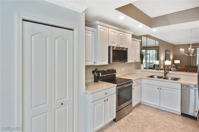 kitchen featuring an inviting chandelier, white cabinetry, appliances with stainless steel finishes, light tile patterned flooring, and sink