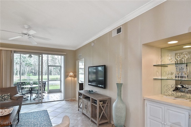 living room with ceiling fan, light tile patterned floors, indoor bar, and crown molding