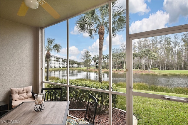 sunroom featuring a water view and ceiling fan