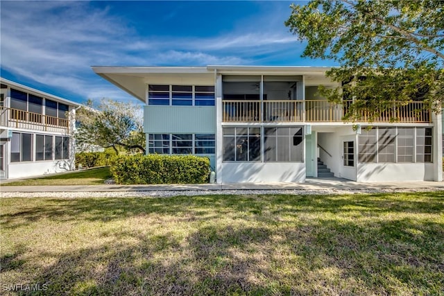 back of property featuring a yard and a sunroom