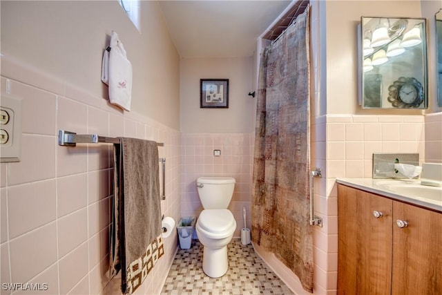 bathroom featuring vanity, tile walls, walk in shower, and toilet