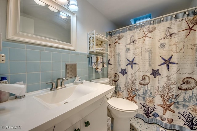 bathroom featuring vanity, toilet, a shower with shower curtain, and tile walls