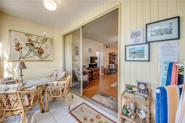 interior space featuring light tile patterned floors and wooden walls