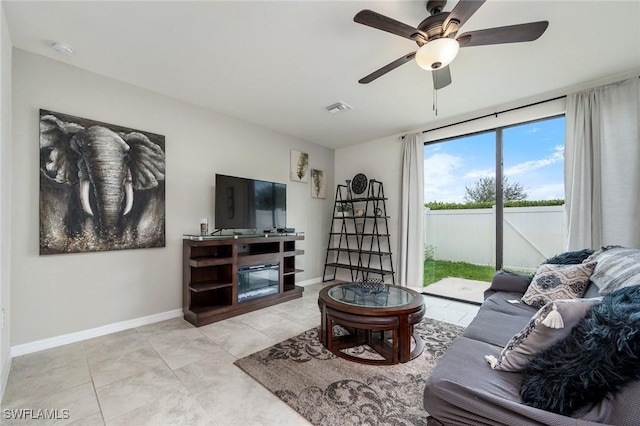 living room with ceiling fan and a fireplace