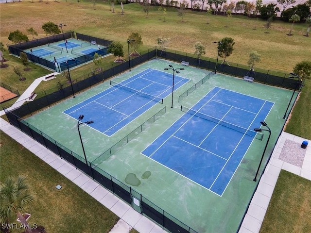 view of tennis court featuring basketball court and a yard